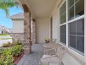 Inviting front porch featuring stone columns, a seating area, and manicured landscaping at 739 Annabell Ridge Rd, Minneola, FL 34715