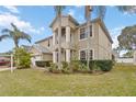 Two-story home showcasing manicured lawn and lush tropical landscaping, complemented by a two car garage at 10068 Chardonnay Dr, Orlando, FL 32832