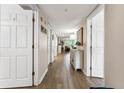 Hallway with white walls and wood-look tile floors leading to a sunlit living room at 1150 Carmel Cir # 503, Casselberry, FL 32707