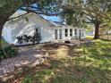 The backyard of the house features trees providing shade for the brick terrace at 11618 Kipling Ct, Clermont, FL 34711