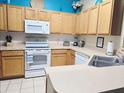 Well-lit kitchen featuring light wood cabinets, white appliances, and decoratively accented with pops of color at 1217 Cypress Pointe Blvd, Davenport, FL 33896