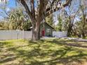 Quaint bungalow with an old oak tree, red door, and a white picket fence at 130 Mandrake St, Orlando, FL 32811