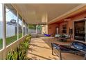 Relaxing screened-in patio featuring ample seating, a ceiling fan, and views of the fenced backyard at 13318 Kitty Fork Rd, Orlando, FL 32828