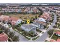 Gorgeous light-grey two-story home with a manicured lawn and mature trees on a corner lot in a Gathering friendly neighborhood at 15732 Shorebird Ln, Winter Garden, FL 34787