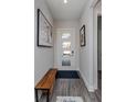 Inviting entryway with a white door that features glass panes, stylish wood floors, and modern artwork at 15732 Shorebird Ln, Winter Garden, FL 34787