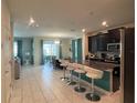 Open-concept kitchen and dining area with island seating and modern appliances at 1580 Tempo Ln, Davenport, FL 33896