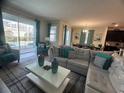 Cozy living room with a large sectional sofa and view of the pool area at 1580 Tempo Ln, Davenport, FL 33896