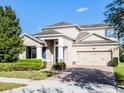 Attractive two-story home boasting a brick driveway, stone accents, and manicured landscaping at 15863 Citrus Grove Loop, Winter Garden, FL 34787