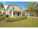 Charming two-story home featuring a covered porch and carport, set in a lush green lawn at 1604 Roosevelt Ave, Orlando, FL 32804