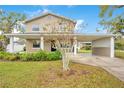 Charming two-story home featuring a covered porch and carport, set in a lush green lawn at 1604 Roosevelt Ave, Orlando, FL 32804