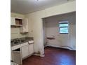 Interior kitchen view featuring outdated cabinets, a double basin sink and damage to the walls and flooring at 1633 Christopher St, Winter Garden, FL 34787