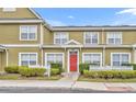 Charming townhome with red door, well-maintained landscaping, and a welcoming exterior at 2602 Lodi Cir # 105, Kissimmee, FL 34746