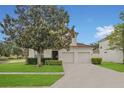 Charming two-story home with a two-car garage, lush landscaping, and a well-maintained lawn at 2621 Archfeld Blvd, Kissimmee, FL 34747