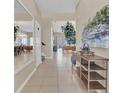 Inviting hallway with tile flooring, decorative mirror, console table, and views of the living spaces at 2621 Archfeld Blvd, Kissimmee, FL 34747