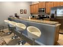 Kitchen bar with granite countertops, stainless steel appliances, and comfortable seating at 2943 Banana Palm Dr, Kissimmee, FL 34747