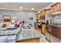 Open kitchen featuring granite countertops, stainless steel appliances, and a convenient breakfast bar at 2943 Banana Palm Dr, Kissimmee, FL 34747