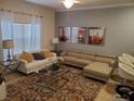 Bright living room with neutral tones, a large window, stylish furnishings, and contemporary art at 2943 Banana Palm Dr, Kissimmee, FL 34747