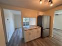 Modern kitchen with stainless steel appliances, granite countertops, new cabinetry, and stylish wood flooring at 4903 Lake Ridge Rd # Ge, Orlando, FL 32808
