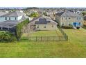 A fenced backyard featuring a green lawn and solar panels on the home's roof at 4976 Creekside Park Ave, Orlando, FL 32811