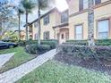 Charming townhome with manicured landscaping, paved walkway, and lush greenery at 569 La Mirage St, Davenport, FL 33897