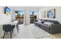 Bright living room featuring a comfortable sofa, dining area, and sliding glass doors to a balcony with palm tree views at 6165 Carrier Dr # 2306, Orlando, FL 32819