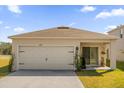 Charming home featuring a two-car garage, front entry door, and a well-maintained lawn at 6895 Botanic Blvd, Harmony, FL 34773
