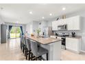 Open-concept kitchen with a large granite island and stainless steel appliances at 6895 Botanic Blvd, Harmony, FL 34773