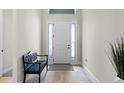 Bright foyer featuring wood-look tile, front door with sidelights, and a bench at 8456 Norwich Way, Mount Dora, FL 32757