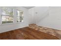 Bright living room with hardwood and tile flooring, a staircase, and large windows at 9026 Paolos Pl, Kissimmee, FL 34747