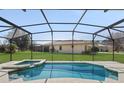 Relaxing screened-in pool and spa with a beautiful backyard view at 9026 Paolos Pl, Kissimmee, FL 34747