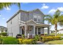 Charming two-story home featuring a manicured lawn and inviting front porch at 9862 Pecan Hickory Way, Orlando, FL 32832