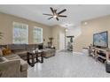 Bright living room featuring tile floors, a ceiling fan, and large windows at 9862 Pecan Hickory Way, Orlando, FL 32832