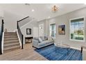 Bright and airy living room featuring a staircase, modern decor, and lots of natural light at 10319 Austrina Oak Loop, Winter Garden, FL 34787