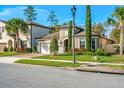 Beautifully landscaped front yard with a well-maintained lawn and brick driveway leading to the garage at 1208 Patterson Ter, Lake Mary, FL 32746