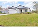 Attractive one-story home featuring a lush green lawn, a two-car garage, and a welcoming front entrance at 1660 5 Ave, Deland, FL 32724