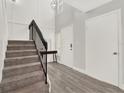 Bright entryway features a staircase with black railings and wood-look flooring at 176 Balfour Dr # 4, Winter Park, FL 32792