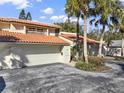 Exterior view of townhomes with terracotta roofs, two car garages, and tropical landscaping at 176 Balfour Dr # 4, Winter Park, FL 32792