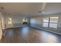 Spacious living room featuring wood-look flooring, neutral paint, and a decorative glass front door at 1926 Binnacle St, Kissimmee, FL 34744