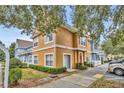 Townhouse exterior with red door, beige siding, and landscaped grounds, offering great curb appeal at 2280 San Vital Dr # 108, Kissimmee, FL 34741