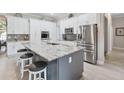 Modern kitchen featuring stainless steel appliances, a large island, and ample counter space at 2929 University Acres Dr, Orlando, FL 32817