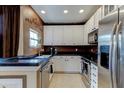 Modern kitchen with stainless steel appliances, white cabinets, and black countertops at 3668 Peppervine Dr, Orlando, FL 32828