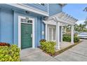 Entrance to blue townhome with covered pergola and a green front door at 4004 San Gallo Dr # 107, Kissimmee, FL 34741