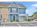 Two-story blue townhome with a pergola, green door and small bushes in front of the door at 4004 San Gallo Dr # 107, Kissimmee, FL 34741