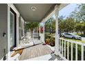 Cozy covered front porch with white railing, outdoor seating, and view of the neighborhood at 4464 Cleary Way, Orlando, FL 32828