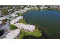 Aerial view of condo buildings next to a lake with a parking lot and well maintained green spaces at 536 Orange Dr # 16, Altamonte Springs, FL 32701