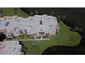 Aerial view of a condominium building with well-maintained landscaping and adjacent to a pond at 536 Orange Dr # 16, Altamonte Springs, FL 32701