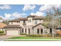 Charming two-story home featuring a tile roof, stone accents, a turret and a three-car garage at 5774 Fulham Pl, Sanford, FL 32771