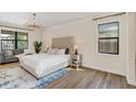 Bright main bedroom showcasing wood floors, a plush bed, and a large window with a view at 5774 Fulham Pl, Sanford, FL 32771