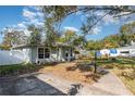 View of charming home with tidy yard, mature trees, and a long driveway at 610 Carolina Ave, St Cloud, FL 34769