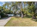 View of a cozy home with mature trees, a manicured lawn and a paved driveway at 610 Carolina Ave, St Cloud, FL 34769